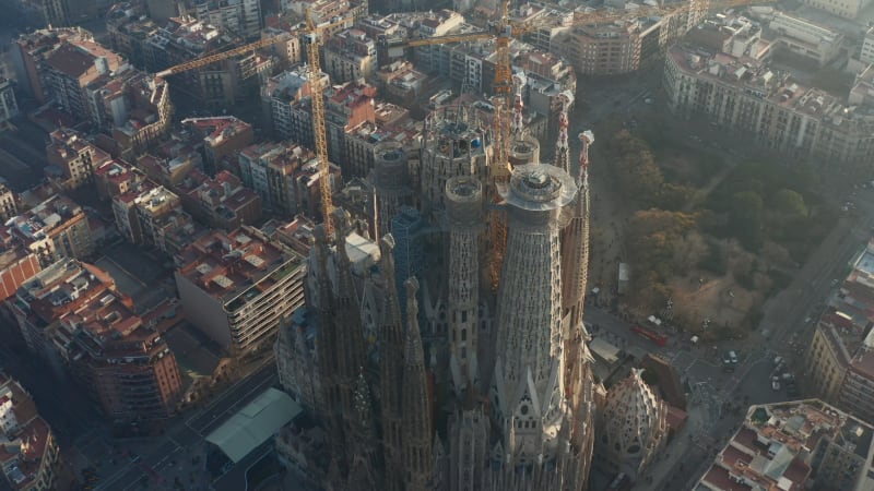 Close up Circling La Sagrada Familia with Cranes in Beautiful City Sunny Haze over Barcelona, Spain