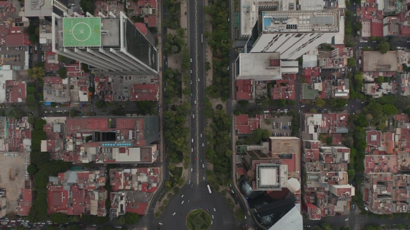 Aerial birds eye overhead top down view of traffic in wide city street. Multilane roundabout crossroad from drone flying forward. Mexico city, Mexico.