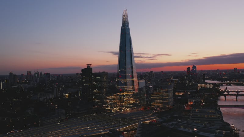 Amazing evening elevated footage of modern skyscraper on River Thames south bank. Tall The Shard after sunset. London, UK