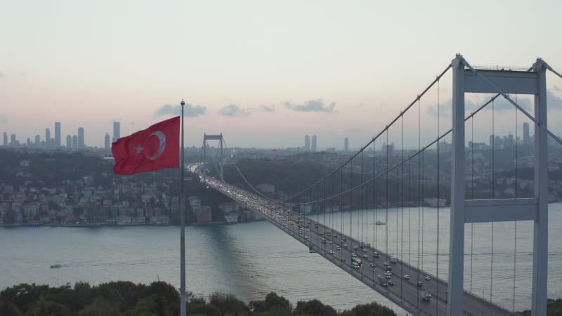 Dolly forward past waving Turkish Flag revealing Bosphorus Bridge, Aerial Wide Shot dolly forward