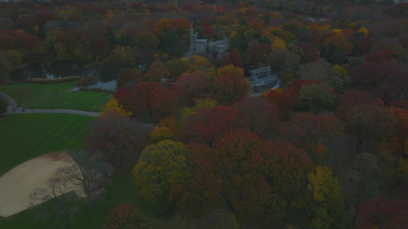 Forwards fly above tourist attractions in autumn Central park. High angle view of Delacorte Theater and Belvedere Castle. Manhattan, New York City, USA