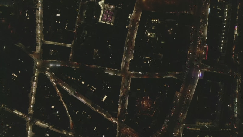 AERIAL: Beautiful Overhead Shot of busy intersection at night with Car traffic and city lights