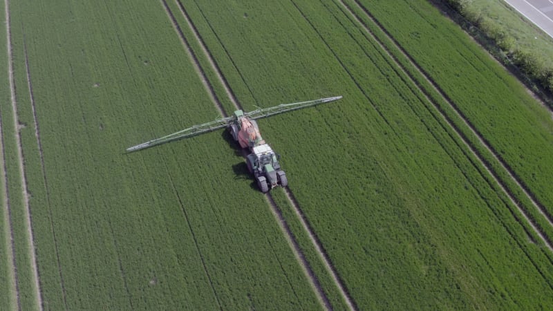 Tractor Spraying a Controversial Glyphosate Herbicide on Agricultural Land