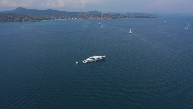 Aerial view of a yacht and many boats along the coast, France.