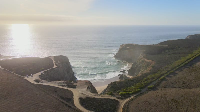 Aerial view of bay protected by high cliffs during sunset