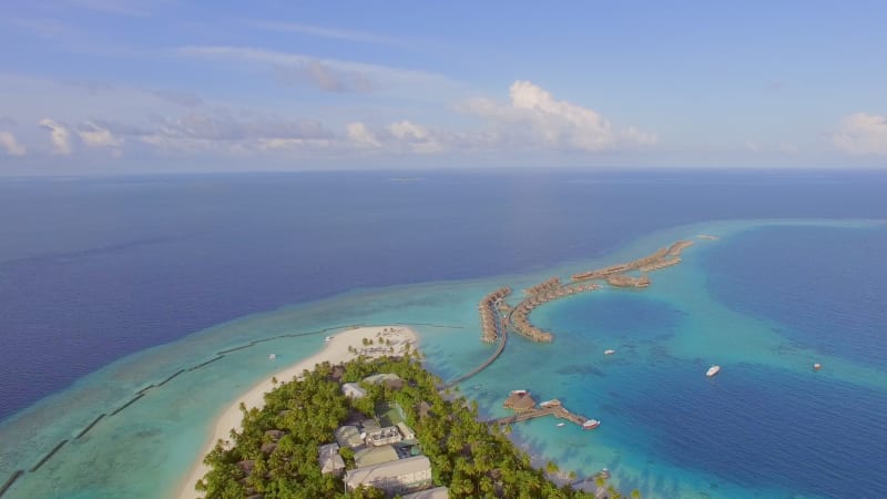 Aerial view of island with a luxury bungalow resort.