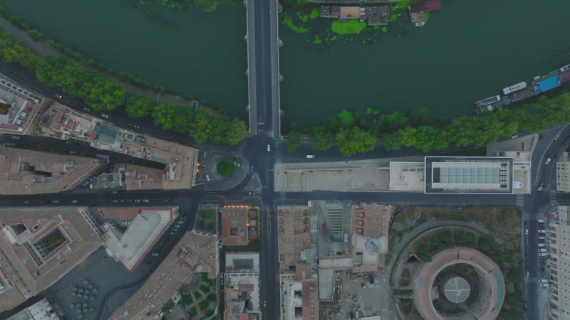 Top down panning footage of buildings and streets in urban borough along Tiber river. Tracking of car passing bridge. Rome, Italy