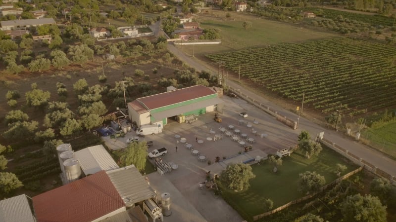 Aerial view of people preparing tables and chairs for a outdoor event.