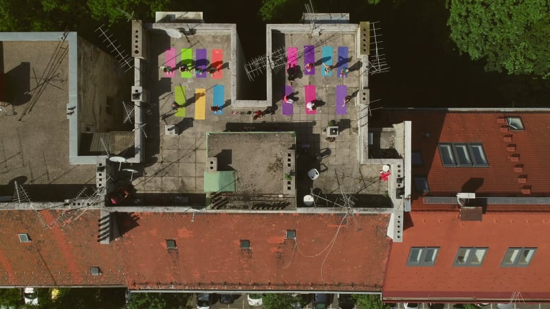 Aerial view of a group of people doing yoga on a rooftop.