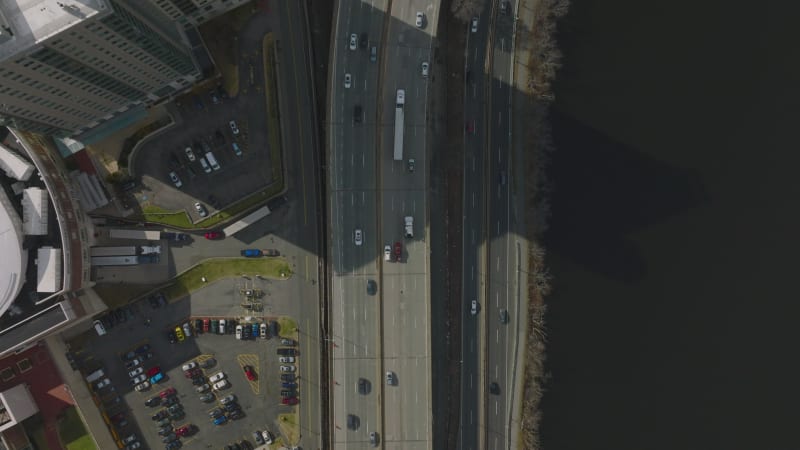 Birds eye shot of busy transport infrastructure. Vehicles passing on highway along high rise buildings on waterfront. Boston, USA