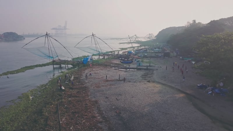 Fishermen working on the beach with large fishing nets in India