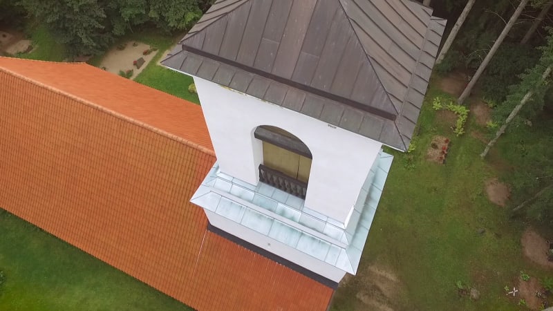 Aerial view of Orthodox Chapel tower located in cemetery on the forest.