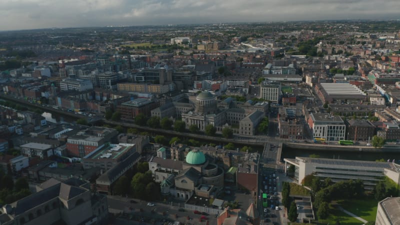 Aerial panoramic view of buildings in large city in flat landscape. Historic Four Courts building on waterfront. Dublin, Ireland