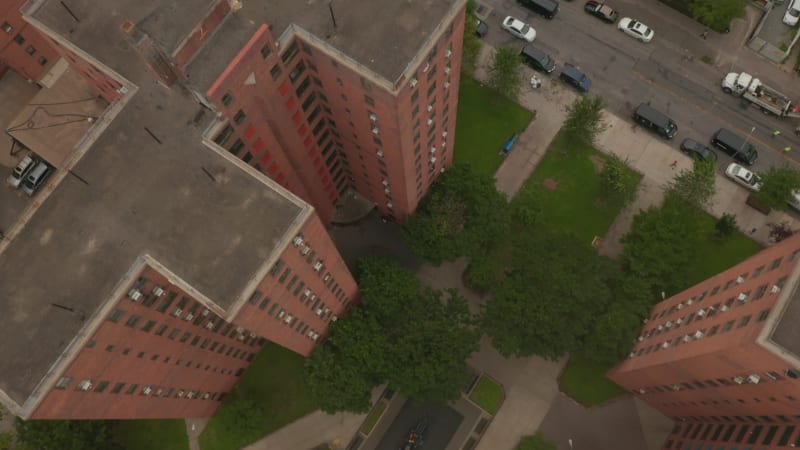 Overhead Top Down Birds View flight over typical New York City neighborhood apartment building with garden, dark mood, Manhattan