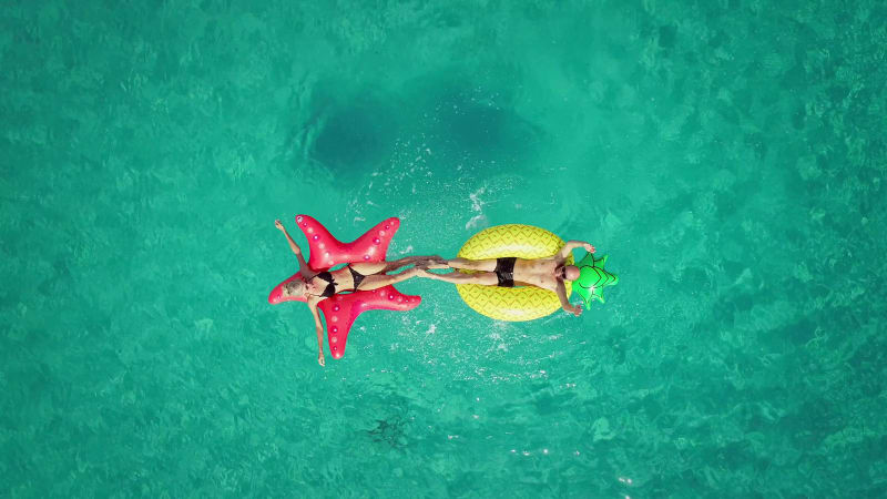 Aerial view of man and woman splashing each other.
