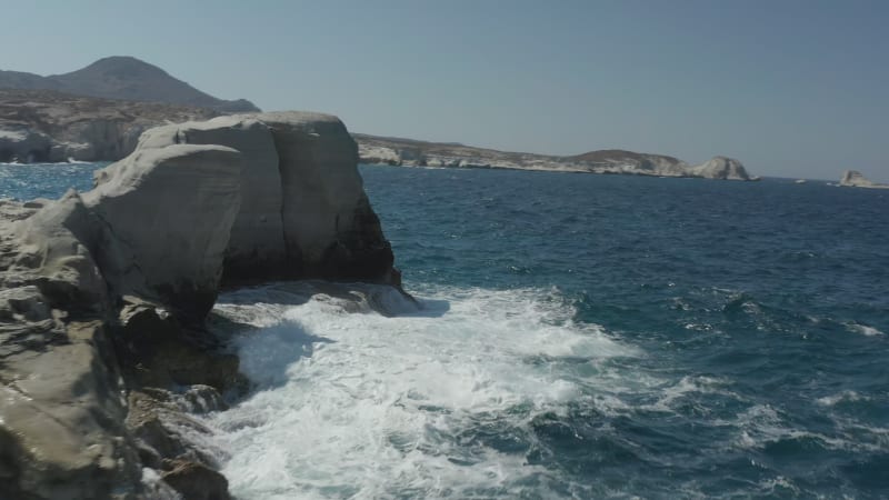 Fast Drone Flight Through Rock Formation at Sarakiniko Lunar Volcanic Beach with Waves crashing on rocks in Milos, Greece