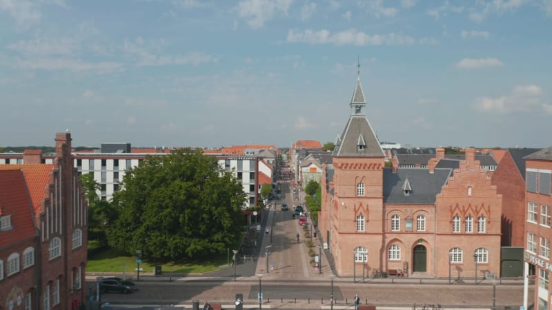 Aerial view backwards of Torvet square in Esbjerg, Denmark with the statue of Christian IX and the Town Hall. Establishing drone view of the historical city centre with lot of tourist and pedestrians