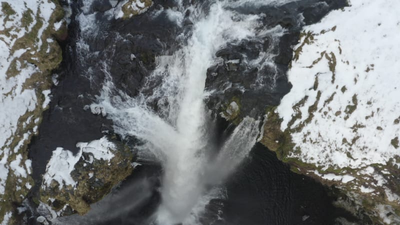 Close Up of Waterfall in Snow, Ice Canyon in Iceland flying upwards Green Grass, Cloudy