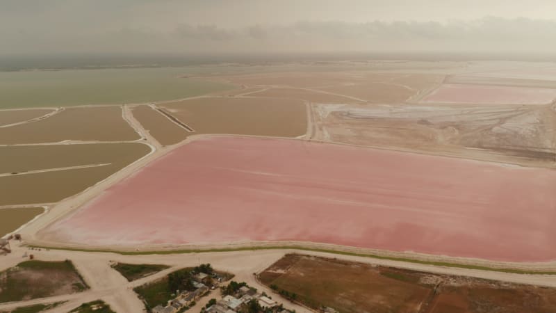 Aerial footage of colourful lakes at seashore. Huge salt evaporation ponds for sea salt extraction. Las Coloradas, Yucatan, Mexico