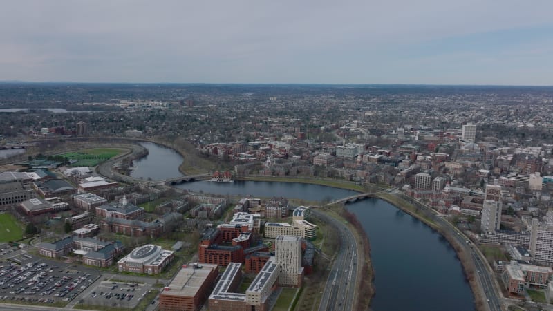 Forwards fly above Charles river. Harvard University and Business school on waterfront from height. Boston, USA
