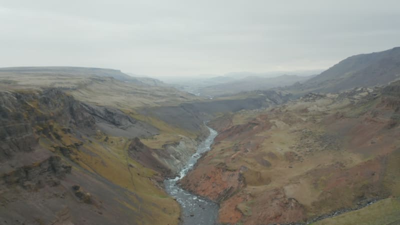 Birds eye stunning and surreal landscape of Haifoss valley in Iceland with river Fossa flowing on riverbed. Aerial view of Landmannalaugar canyon valley with green moss covered canyon