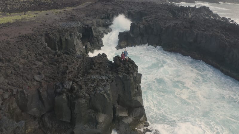 Aerial view of couple on coastal cliffs.