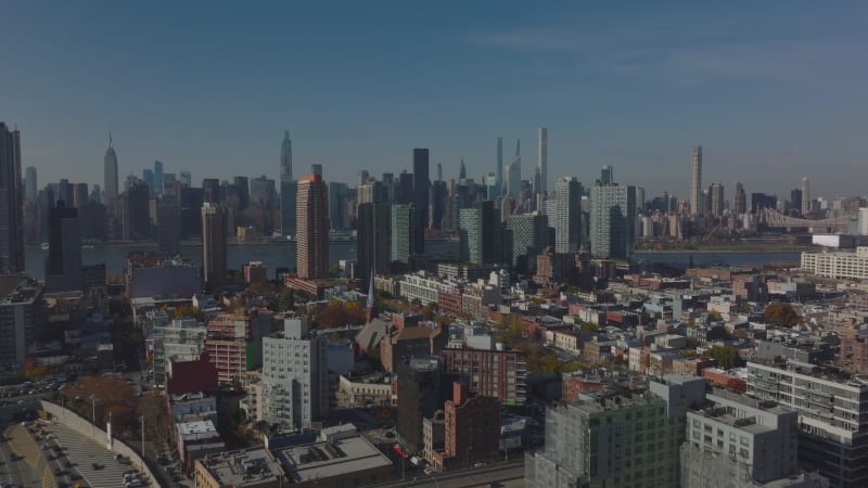 Rising shot of residential Queens borough. Revealing tall downtown office towers on Manhattan. New York City, USA