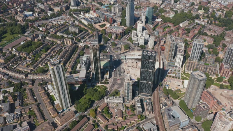 Aerial shot of group of skyscrapers at Elephant and Castle. Tall modern Strata apartment building with wind turbines on top. London, UK