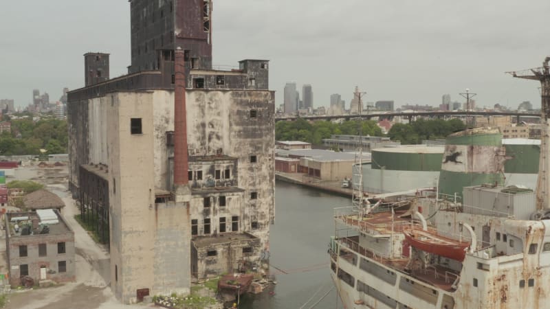 Over Rusty old Cargo Ships and old Warehouse in the Docks of New York City on a cloudy Grey day