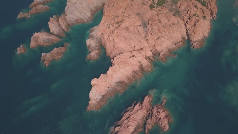 Aerial view of a reddish remote reef near Isola Rossa, Sardinia.