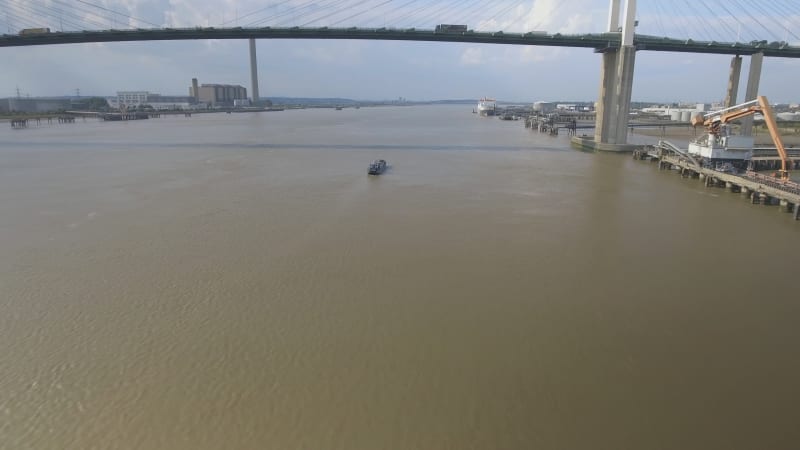 Small Boat Travelling Under Bridge