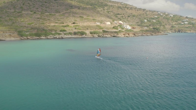 Aerial view of man doing windsurfing at the sea.