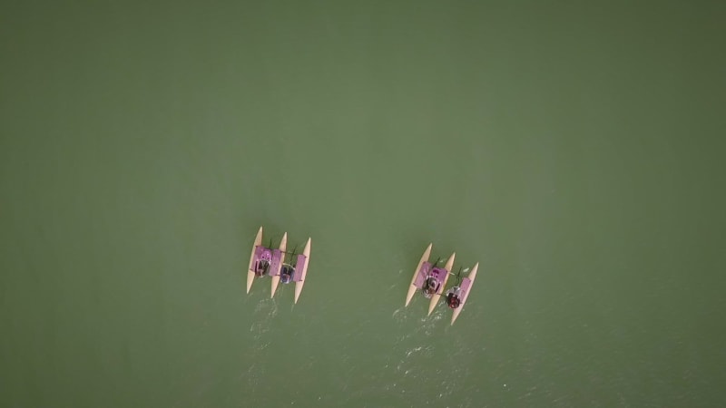 Aerial view of group of people on water bike pedal boats.