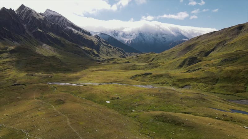 Aerial view of alpine plain with river gorge and mountains in Greina