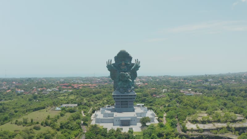 Aerial dolly view of Garuda Wisnu Kencana statue in Bali, Indonesia. Forward dolly aerial view of large religious sculpture of Vishnu riding Garuda