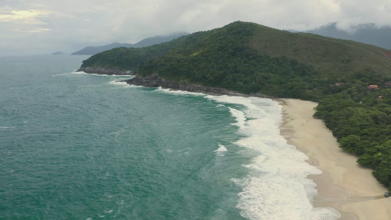 Aerial view of a surfer on a beautiful tropical beach in Brazil