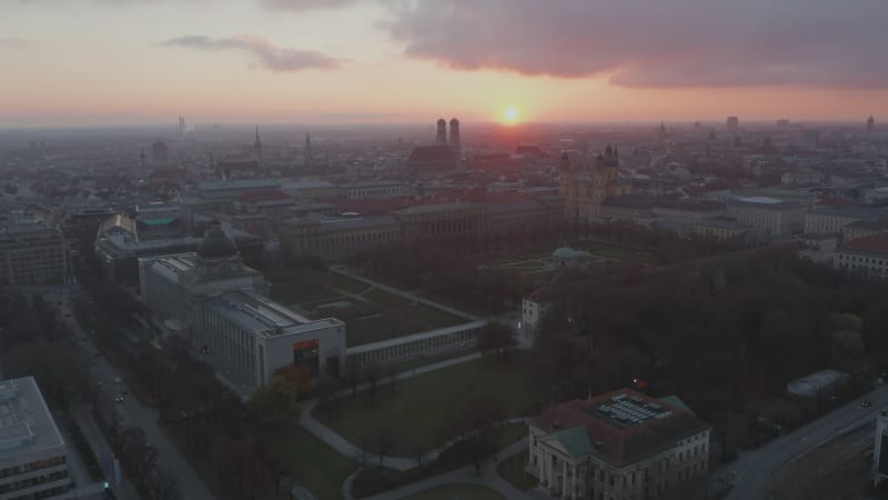 Court Garden in Munich, Germany at Golden Hour Sunset with View over the whole City, Aerial Drone Shot tilt up above Frauenkirche Cathedral Famous Building