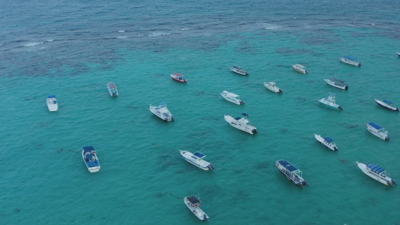 Moored boats swaying on the water surface. Stunning seascape with turquoise Caribbean Sea