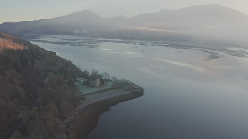 Dunderave Castle on lake bank surrounded by mountains