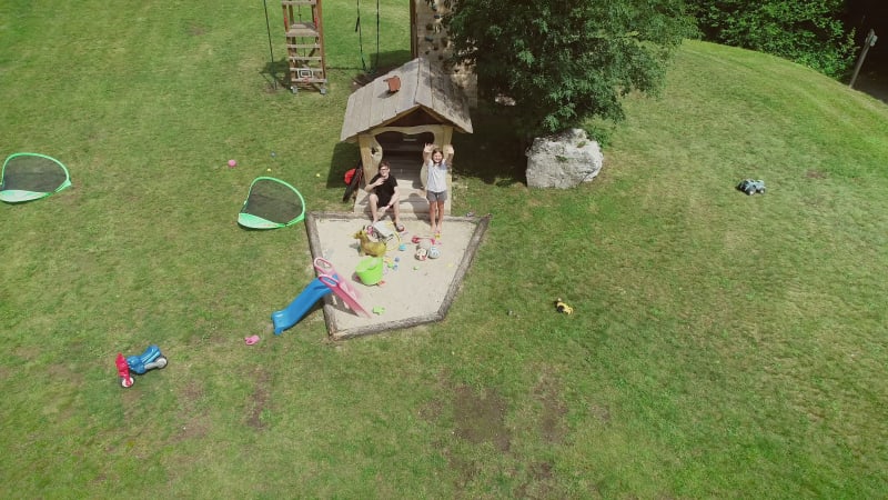 Aerial view of kids waving in playground camping site.