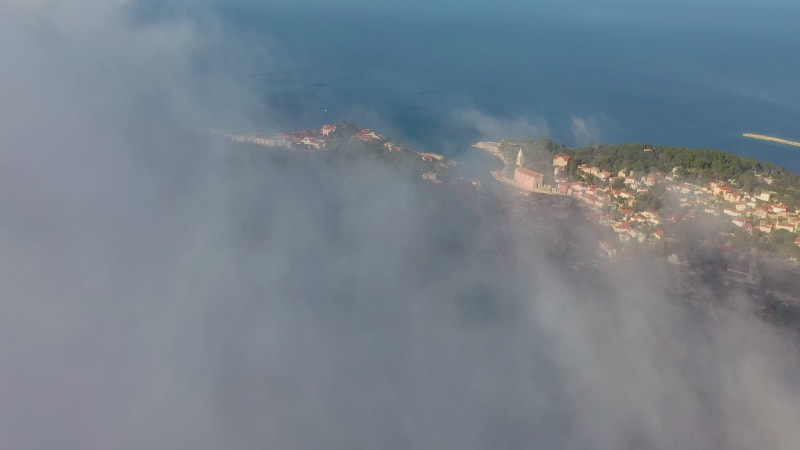 Aerial view above the clouds of Veli Lošinj cityscape.