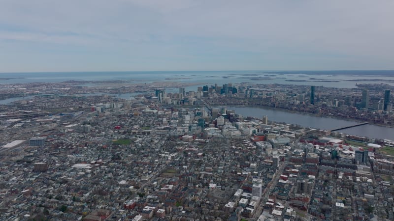 Amazing cinematic aerial panoramic footage of metropolis on sea side. Backwards reveal of buildings in residential borough, downtown skyscrapers and islands in background. Boston, USA