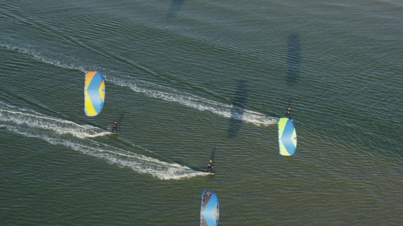 Four Kitesurfers Riding on the Waves in Tweede