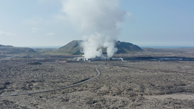 Aerial view flying over a geothermal power plant in Iceland. Drone View over power station producing alternative green energy steaming hot water