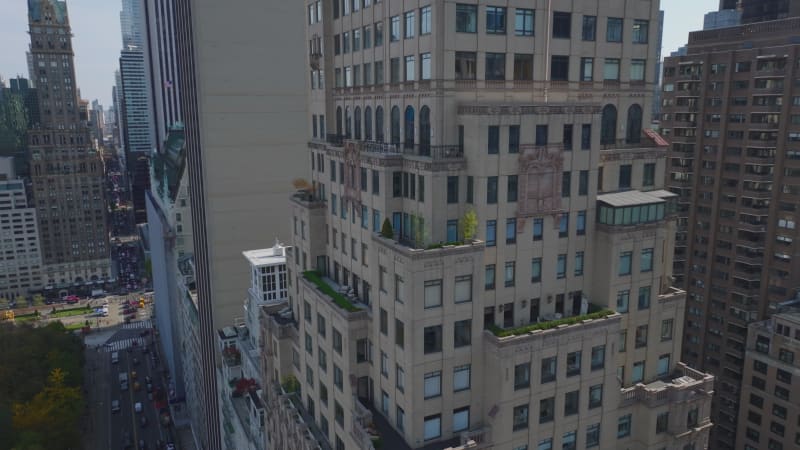 Ascending aerial footage of high rise luxurious hotel building. Tilt down to streets around. Manhattan, New York City, USA