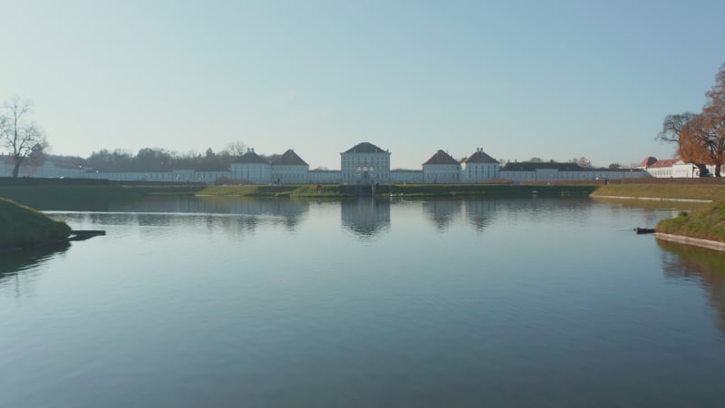 The Majestic Nymphenburg Palace or Schloss Nymphenburg in Munich, Germany with beautiful Lake with Swans in front of Royal Palace, Aerial Establishing Shot forward dolly