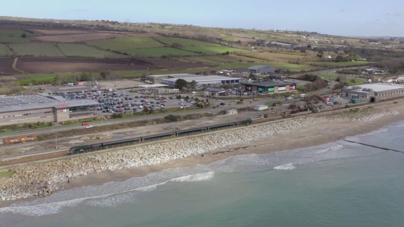 Commuter Train Accelerating Alongside the Sea