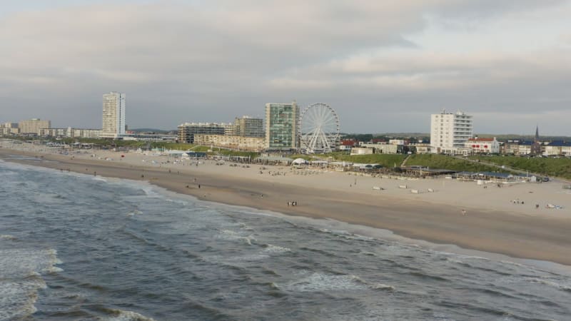 Stunning aerial view of the people on the beach with windy sea waves