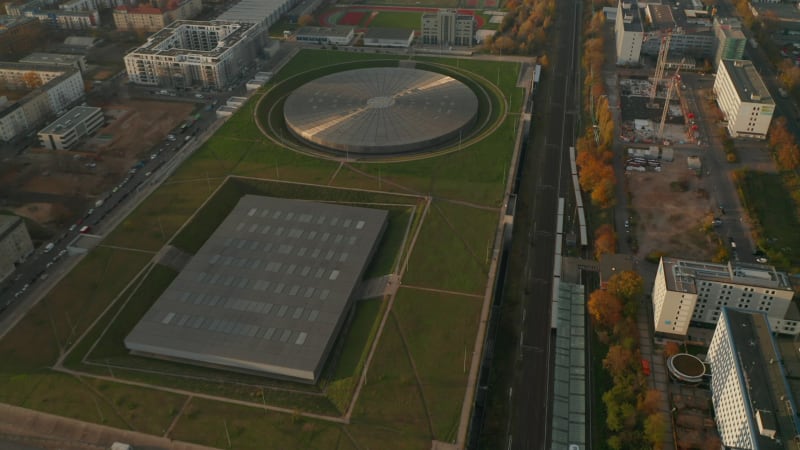 Establishing Aerial Shot above Futuristic Velodrome Building cycling Arena in Berlin, Germany, Aerial tilt up view at Sunset