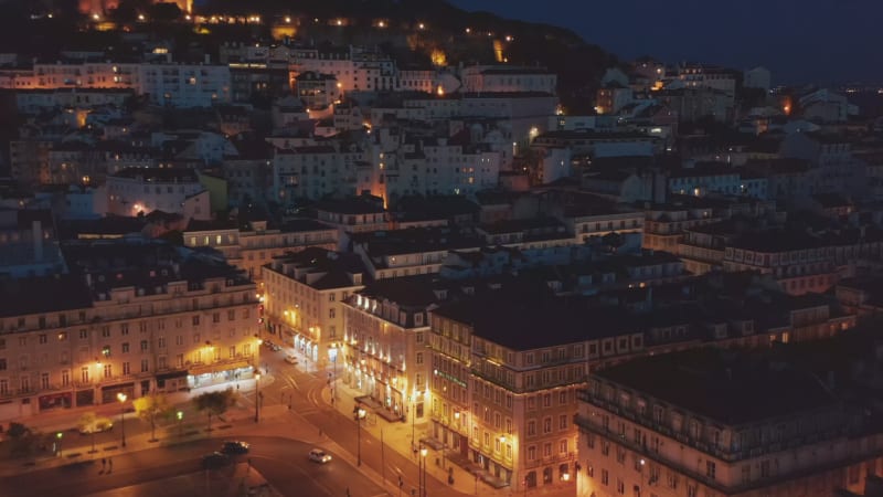 Close up aerial view of modern buildings and large public square in urban city center of Lisbon, Portugal with castle on the hill